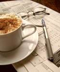 Coffee, glasses, and a pen on a newspaper