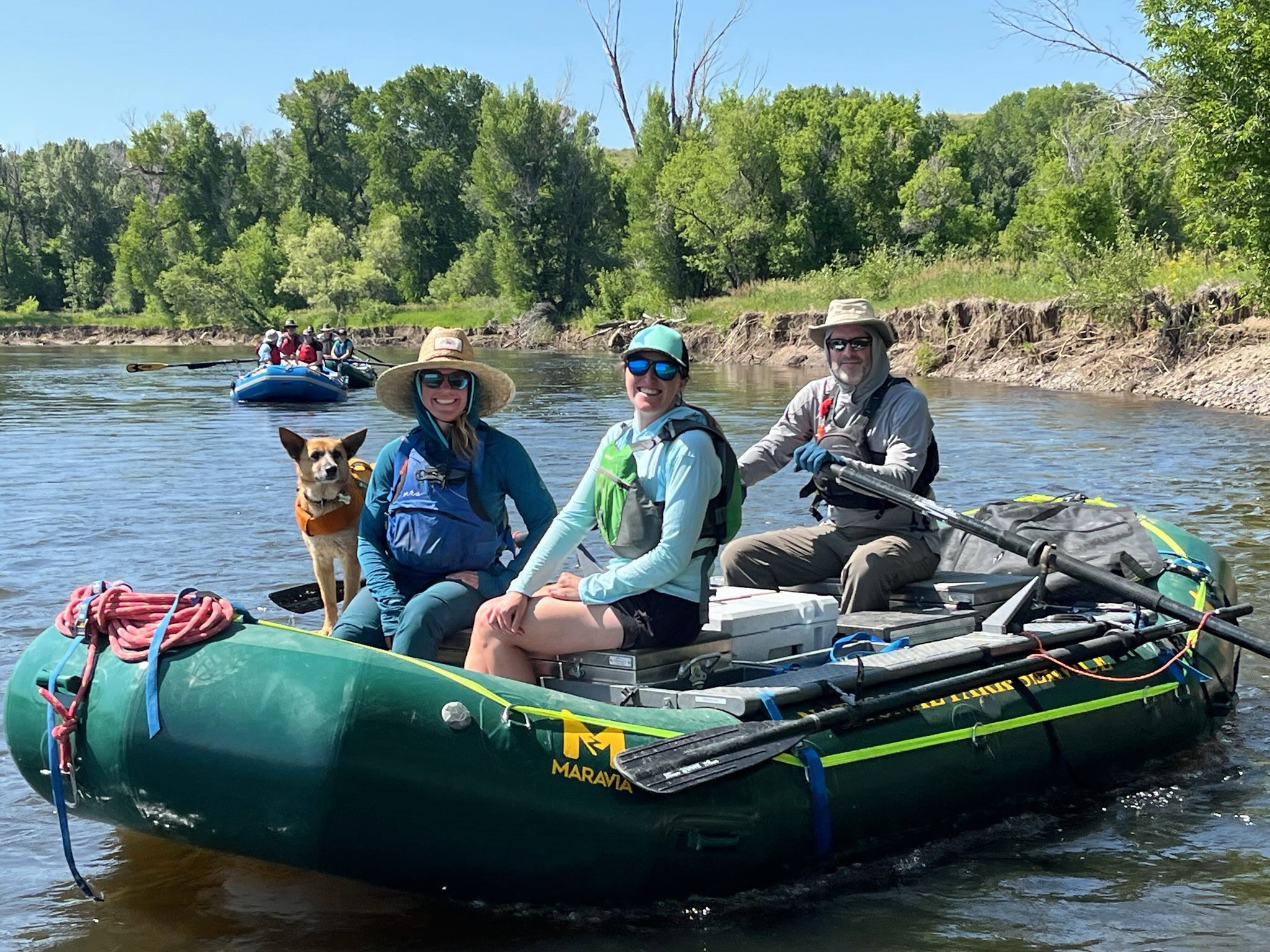 A dog and three people on a raft floating down the Yampa river