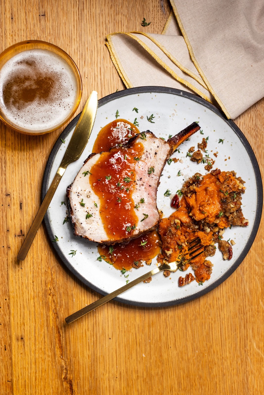 A plate with a roasted pork rib and mashed sweet potatoes