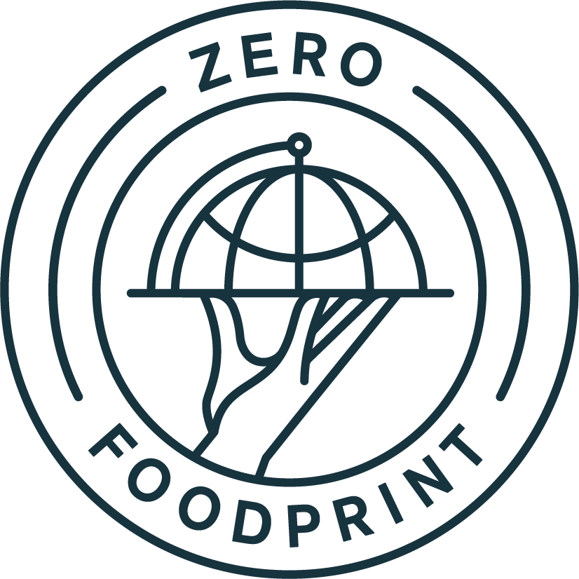 The Zero Foodprint logo is a circle with a hand carrying a serving tray that holds a globe. 