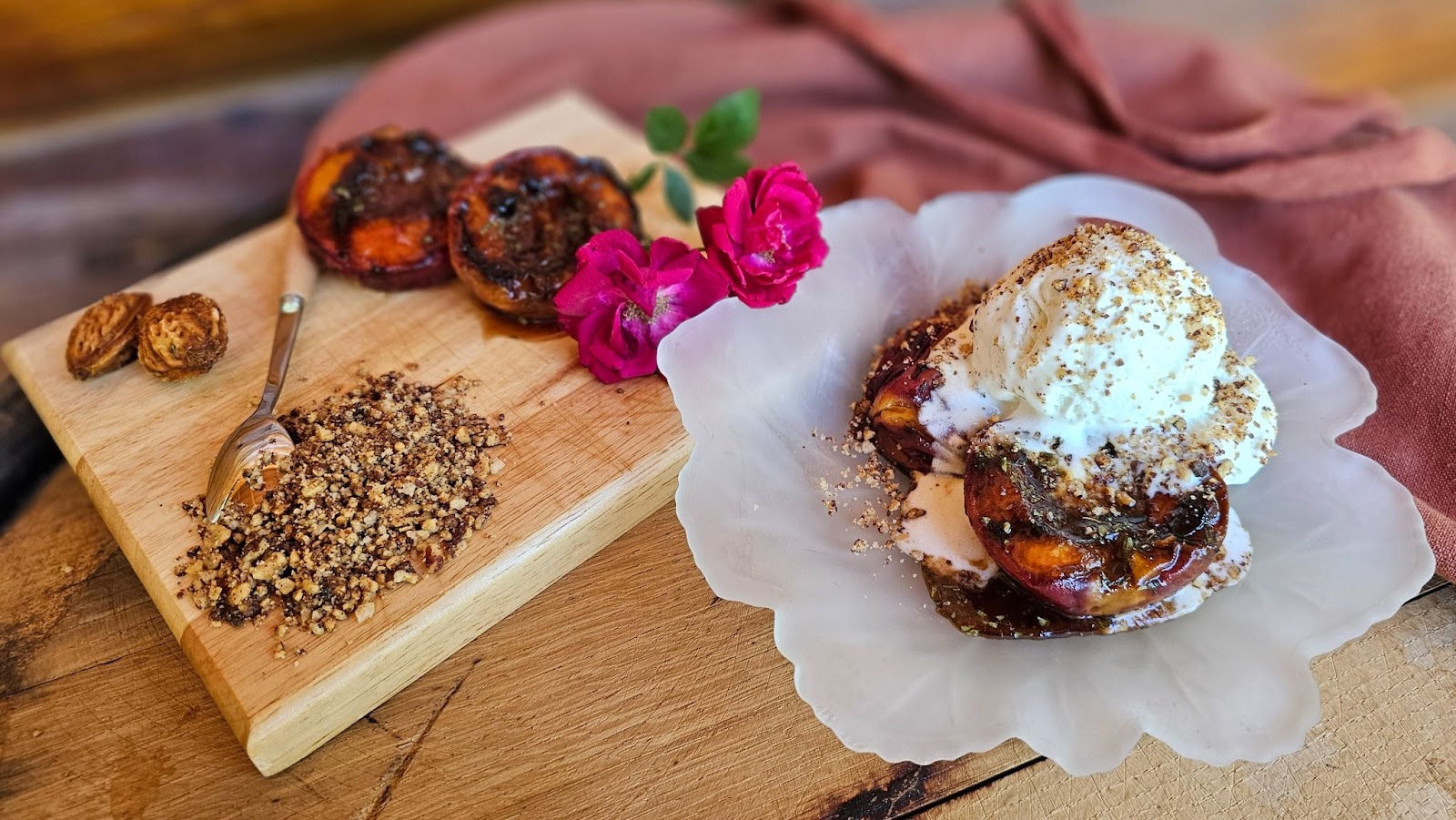 A grille peach on a flower shaped plate, topped with ice cream and crushed nuts