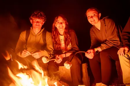 Junior leaders roast marshmallows by the fire at Camp Rocky 2023