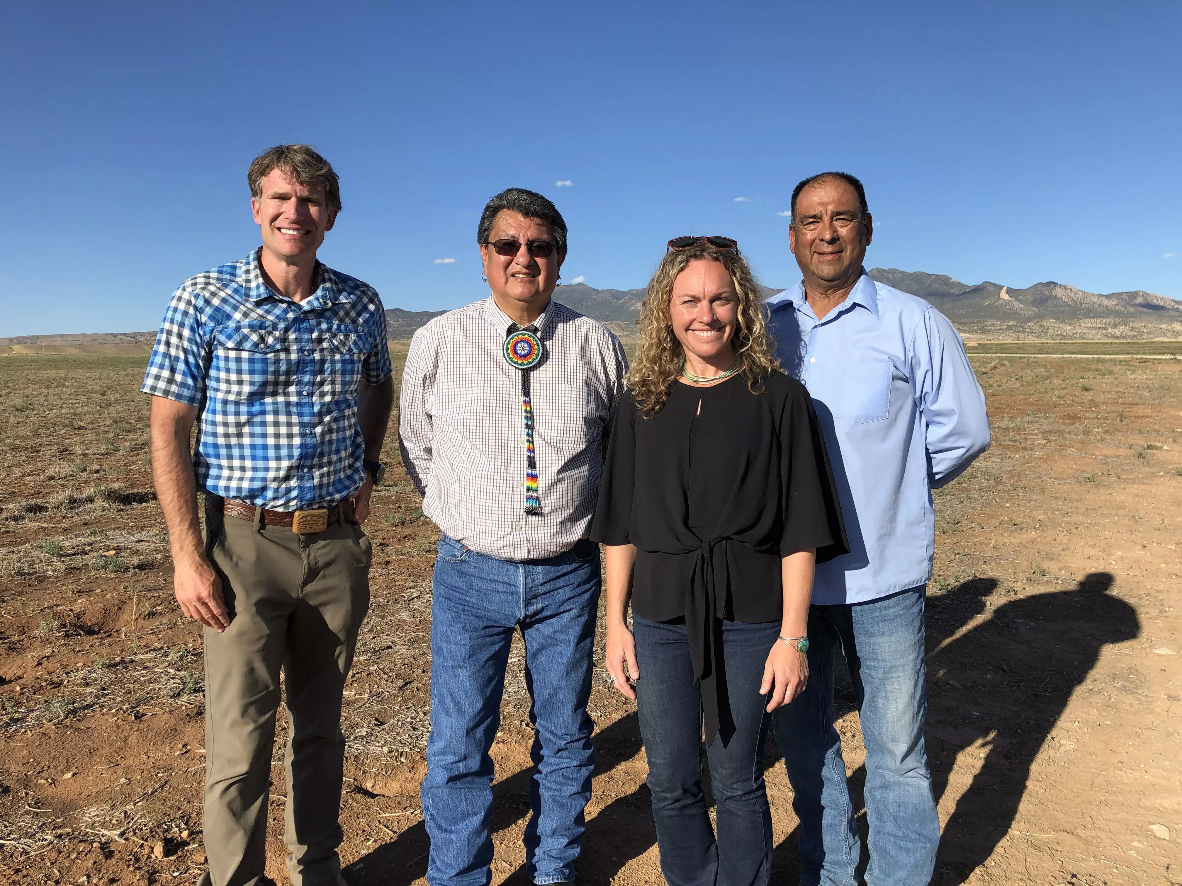 l-r: Dan Gibbs, Manuel Heart, Kate Greenberg, and Simon Martinez pose in a field for the camera.
